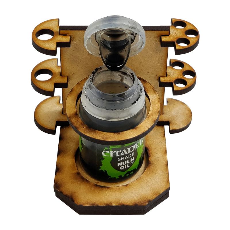 Can you name ANYTHING worse than spilling a brand new pot of Nuln Oil? We didn't think so.Let that be a thing of the past with our No Spills pot and brush holder.This gadget will save you time and money when painting by reducing the amount of time you spend mopping up puddles of liquid gold.PLUS it comes with handy brush holders that clip onto the side so your wash brushes are never far away!Precision cut from 3mm MDF. This kit is supplied unassembled.Pleae note, brushes and paint are not included. The Colour Forge No Spills - Paint Pot Holder - TCF-ACC-006 - 5060843100638